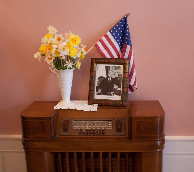 a 1940s floor radio with Roosevelt portrait and daffodils
